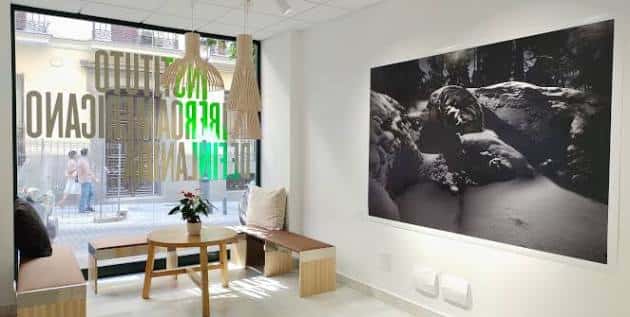 Interior moderno del Instituto Iberoamericano de Finlandia con zona de descanso y arte en la pared