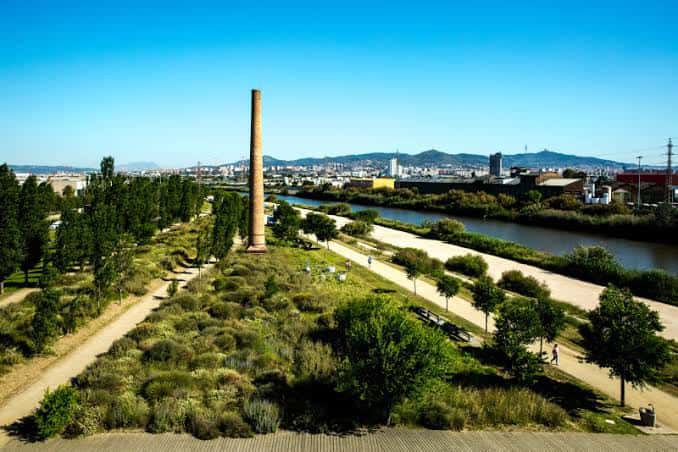 Amplia vista aérea del parque mostrando senderos, vegetación mediterránea y el río