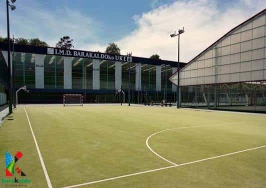 Campo exterior de fútbol en césped artificial frente al edificio principal