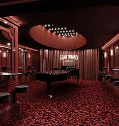 Interior del Gran Tonino Piano Club con piano de cola y alfombra roja