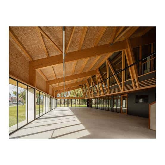 Interior espacioso del centro con estructura de madera y grandes ventanales
