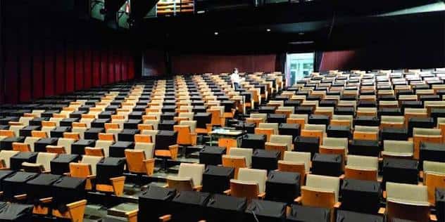 Interior amplio del teatro con butacas negras y naranjas dispuestas en gradas