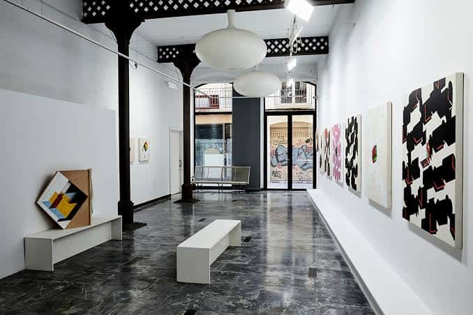 Interior de la galería Antoni Pinyol con obras de arte abstracto en las paredes