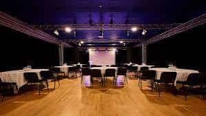 Sala de eventos con mesas redondas y sillas dispuestas para cena