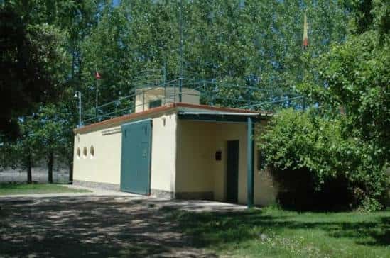 Vista exterior de las instalaciones del Club Náutico con edificio amarillo y puerta verde