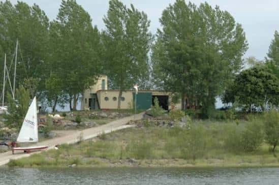 Edificio principal del club náutico rodeado de árboles junto al río