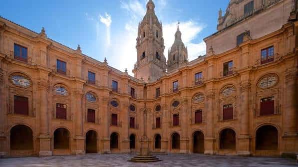 Patio principal de la Universidad Pontificia con fachada barroca y torres al fondo