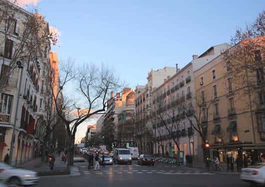 Vista panorámica de la calle José Ortega y Gasset con edificios históricos y tráfico urbano