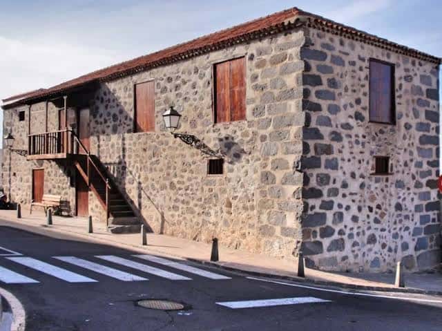 Fachada de piedra volcánica del Centro de Oficios El Granero con escalera exterior y farol tradicional