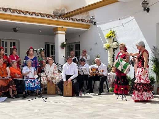 Celebración de la Fiesta de la Cruz en el patio del Hogar Social con músicos y cantantes