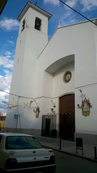 Fachada principal de la Iglesia de Santa Bárbara con campanario y cielo azul