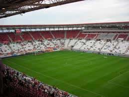 Vista interior del Estadio Enrique Roca con gradas rojas y blancas y campo de fútbol