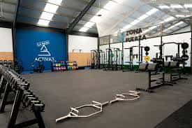 Interior del espacio como gimnasio con zona de fuerza y equipamiento deportivo