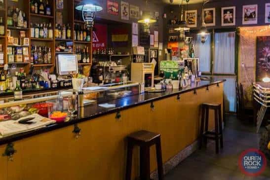 Interior de la tetería con barra y estanterías llenas de botellas