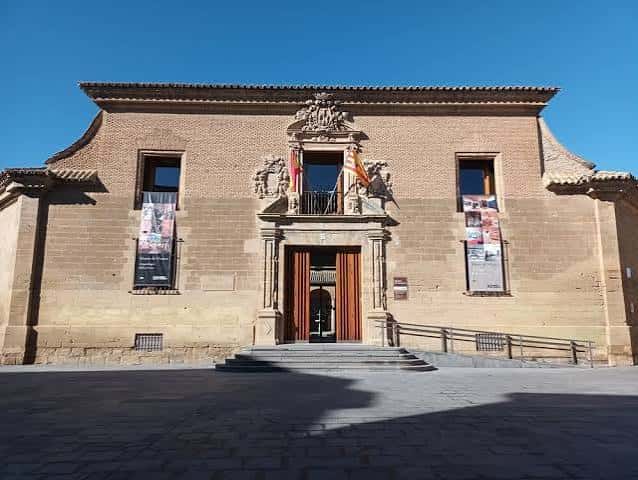 Fachada principal del Museo de Huesca con detalles arquitectónicos y banderas