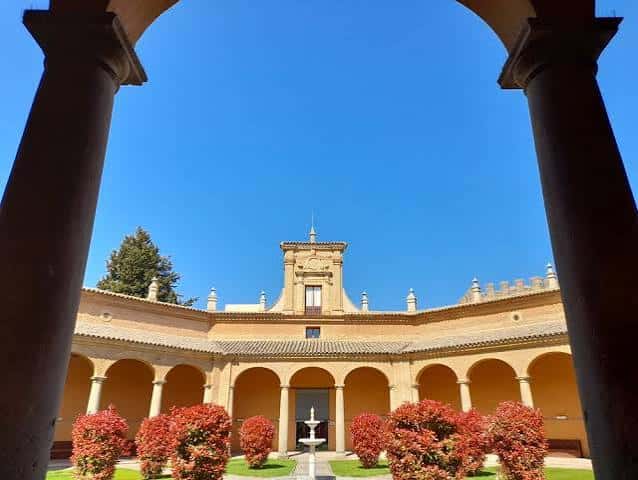 Vista panorámica del patio desde los arcos con cielo azul despejado
