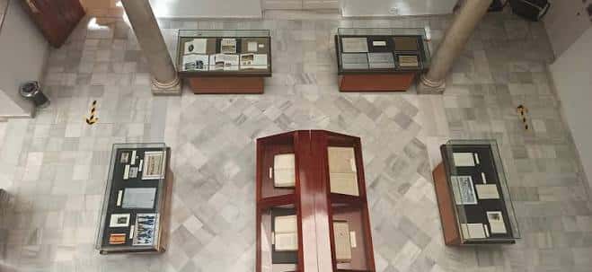 Vista cenital de la sala de exposiciones con vitrinas y libros antiguos