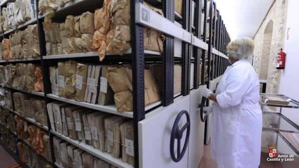 Interior del archivo mostrando estanterías móviles con documentos históricos y personal trabajando