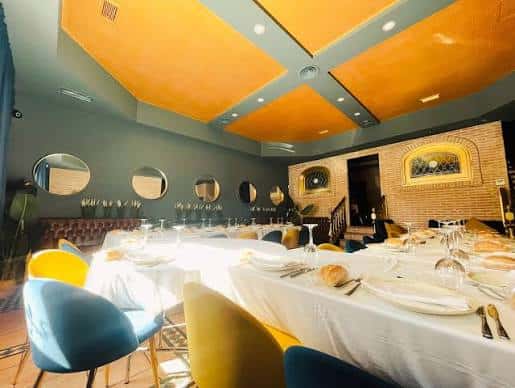 Sala principal del restaurante Ozark con techo naranja y mesas cubiertas con manteles blancos
