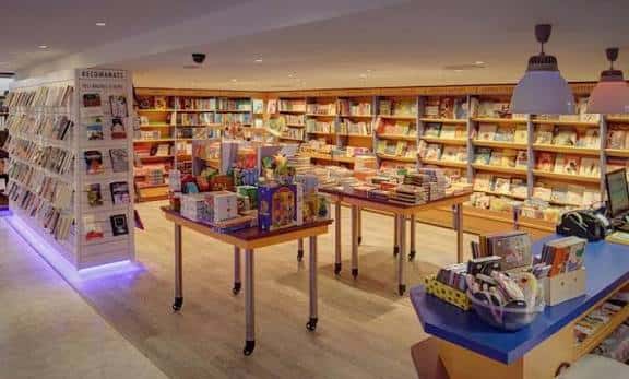 Interior de la libreria con estanterias llenas de libros y mesas de exposicion