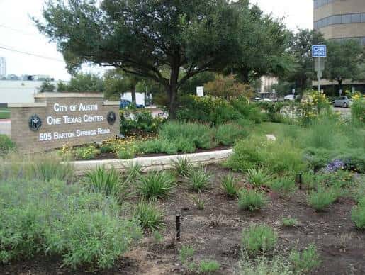 Señal de entrada al One Texas Center con paisajismo