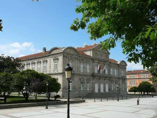 Vista exterior completa del Pazo da Deputación con plaza y árboles en primer plano