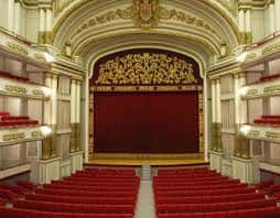Vista frontal del auditorio con escenario y cortina roja
