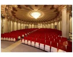 Sala de espectáculos con iluminación central y disposición semicircular de asientos