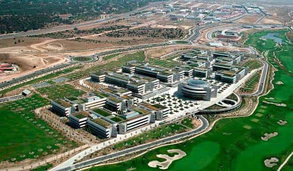 Perspectiva elevada del campus corporativo rodeado de campos de golf y carreteras