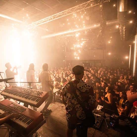 Concierto en vivo con público y banda en el escenario