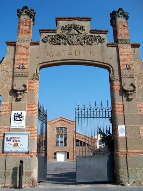 Puerta monumental de entrada con el letrero 'MATADERO' y detalles ornamentales de piedra