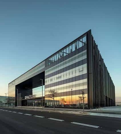 Fachada exterior moderna del edificio DFactory Barcelona al atardecer