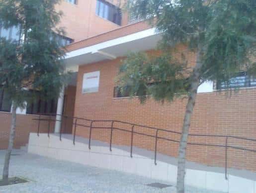 Entrada accesible del centro cívico con rampa y vegetación alrededor