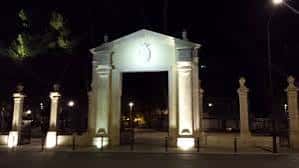 Puerta de Hierros iluminada por la noche con ambiente festivo