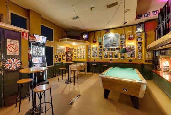 Sala de juegos con mesa de billar y decoración temática náutica