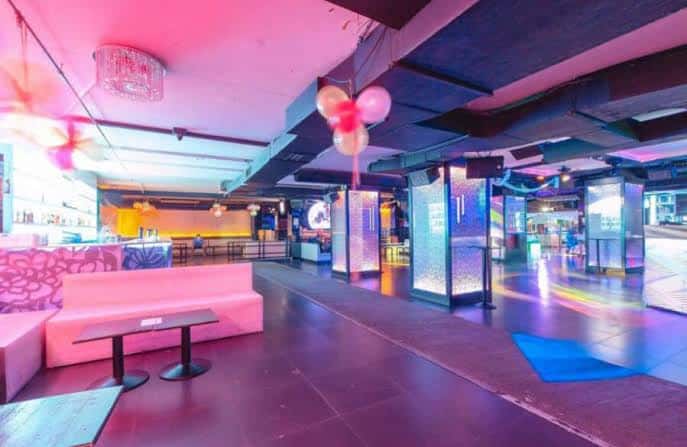 Interior de local con iluminación de neón rosa y azul, ideal para fiestas privadas