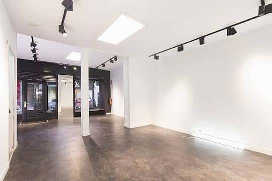 Espacio amplio y moderno con suelo oscuro y techo blanco, perfecto para eventos