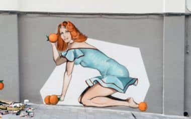 Pintura mural de estilo pop-art con una figura femenina y naranjas