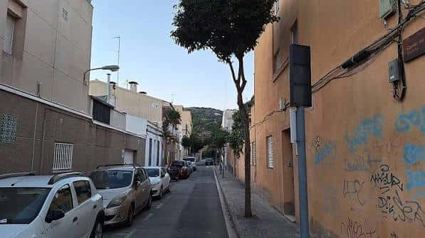 Calle estrecha con edificios residenciales y grafitis en les Guixeres