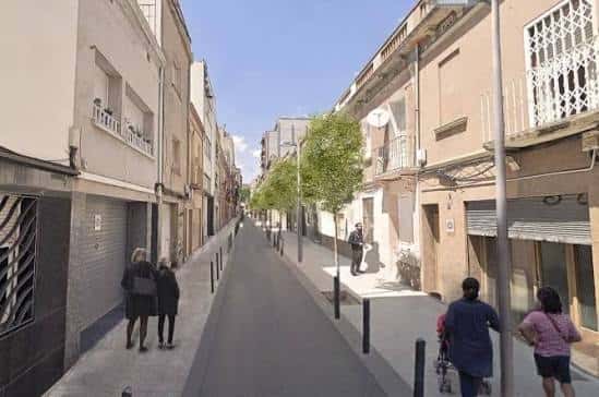 Calle peatonal con personas caminando y fachadas tradicionales
