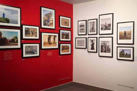 Exposición de arte fotográfico con paredes rojas y blancas