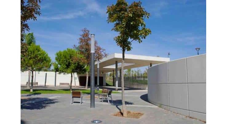 Área de descanso con pérgola moderna y bancos en el parque