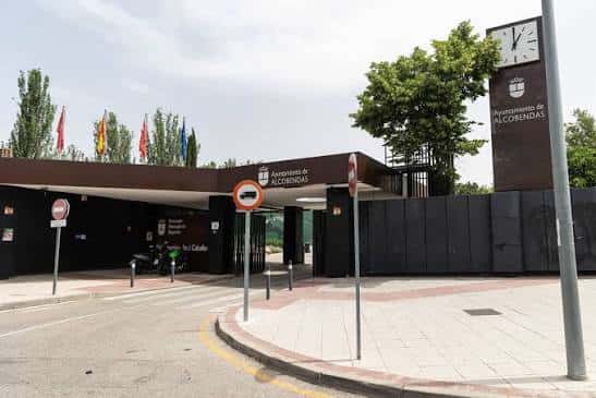 Vista exterior de la entrada del complejo deportivo bajo cielo nublado