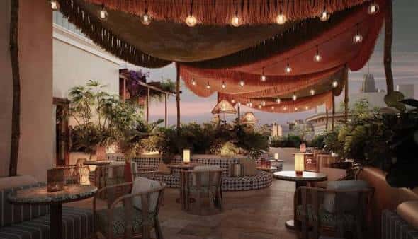 Terraza exterior con toldos, luces colgantes y plantas