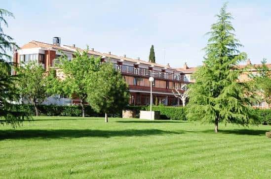 Vista exterior de una residencia geriátrica con jardines y árboles