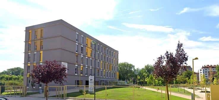 Edificio de residencia con detalles en amarillo y entorno verde