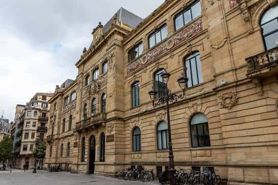 Fachada detallada del edificio histórico en la Calle Urdaneta con ornamentos arquitectónicos y farolas antiguas