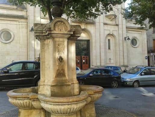Fuente de Font Redona en Alcoy con fachada histórica al fondo