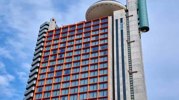 Vista exterior del Hyatt Regency Barcelona Tower con su distintiva fachada naranja y estructura moderna
