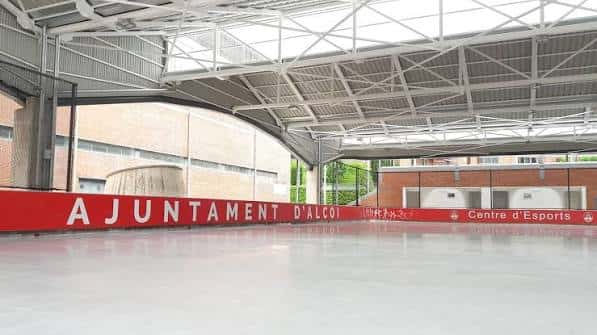 Vista interior del polideportivo municipal con pista de hielo y estructura metálica